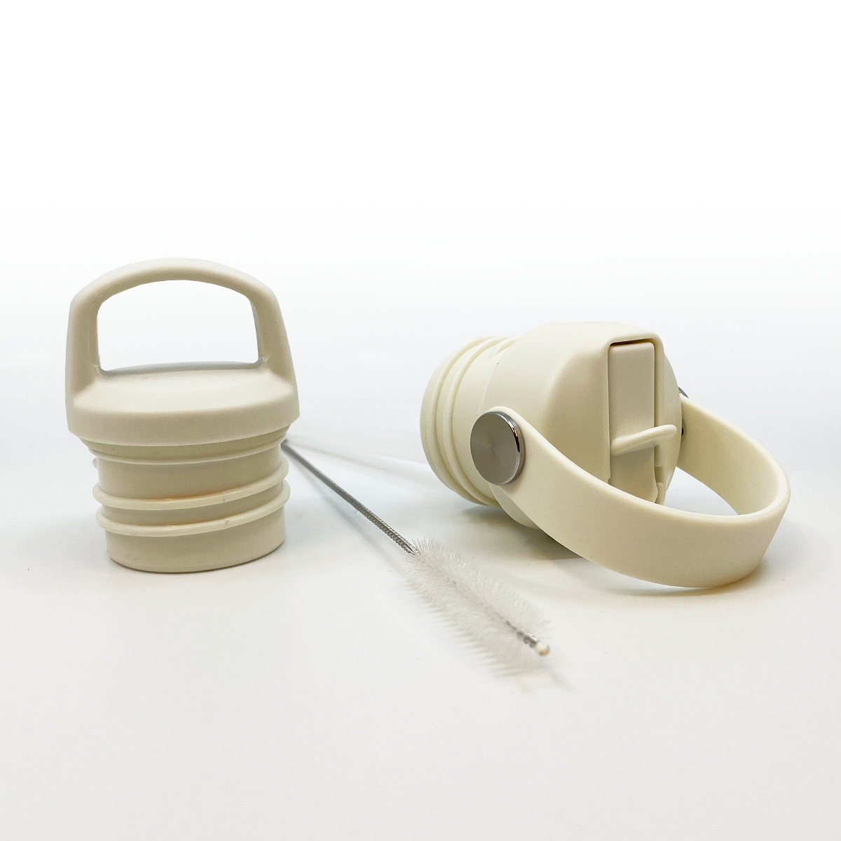 De gewone dop en rietjesdop met schoonmaakborsteltje voor de RVS flessen van Smikkels