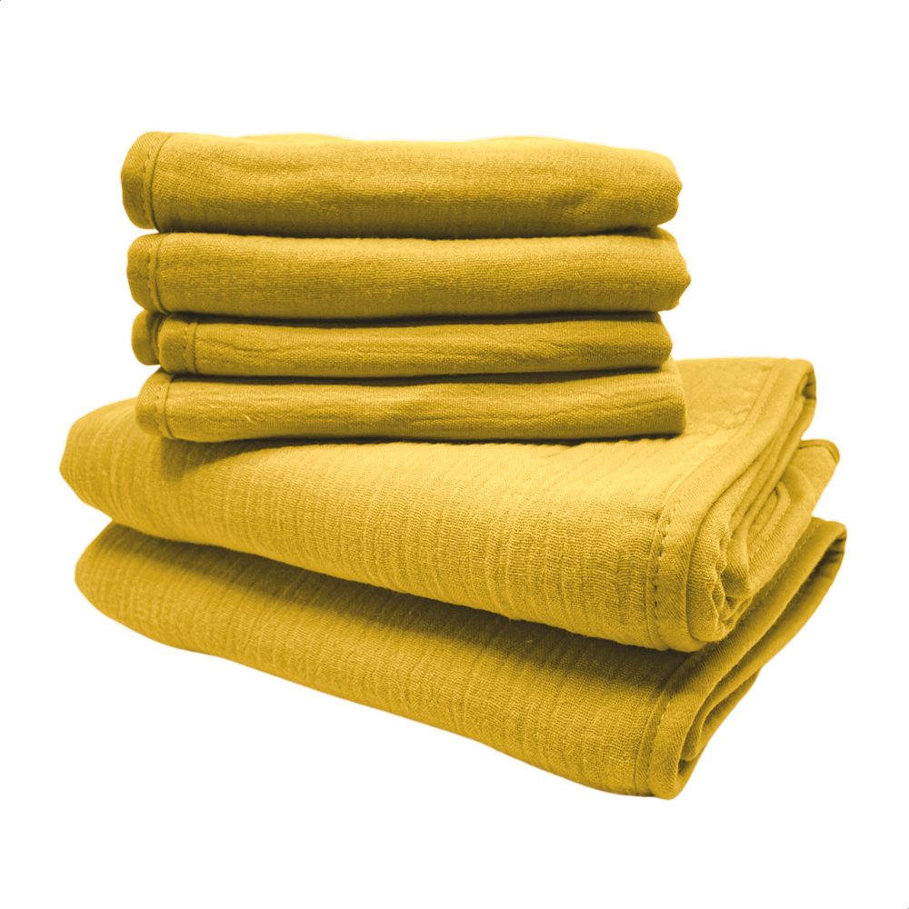 Een stapel van gele monddoekjes en babyhanddoeken van Smikkels met een grote rode strik er bij