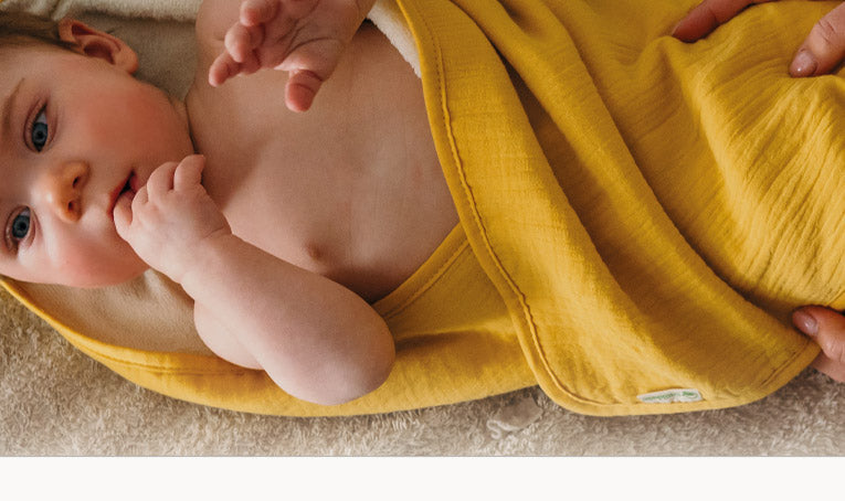 Baby gewikkeld in gele babydoek van Smikkels