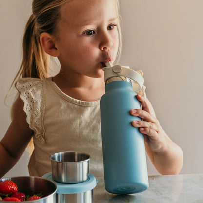 Meisje drinkt uit blauwe thermos drinkfles