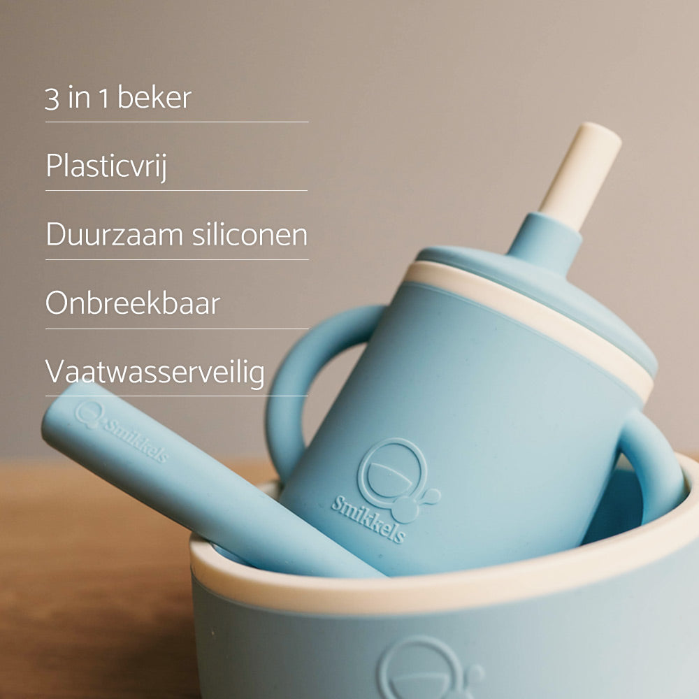 USP's van de blauwe siliconen 3-in-1 beker van Smikkels. De beker staat samen met een lepel in het blauwe siliconen kommetje van Smikkels