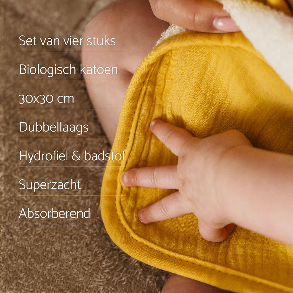 USP Smikkels monddoekjes. Baby hand ligt op een geel monddoekje van smikkels