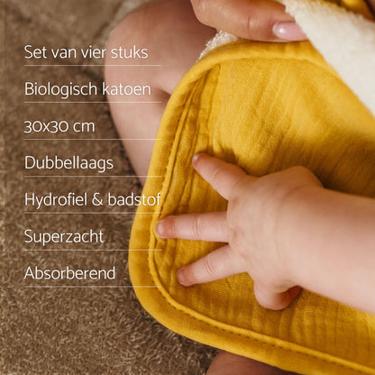 USP Smikkels monddoekjes. Baby hand ligt op een geel monddoekje van smikkels