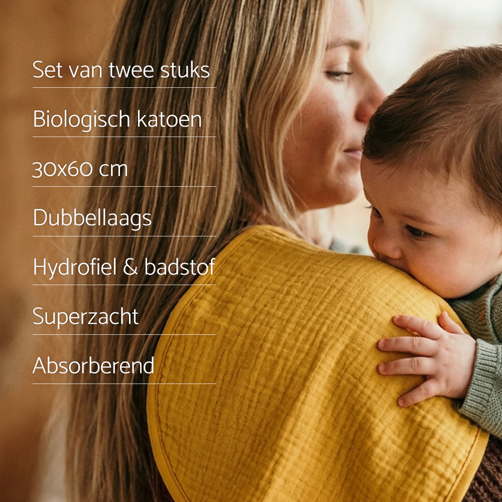 USP Smikkels schouderdoek. In de achtergrond een groene Smikkels schouderdoek over de schouder van een moeder met daartegen een baby