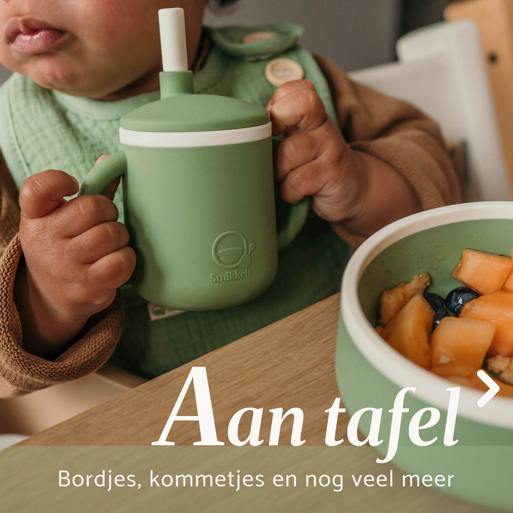 Groene siliconen drinkbeker van Smikkels vastgehouden door kind